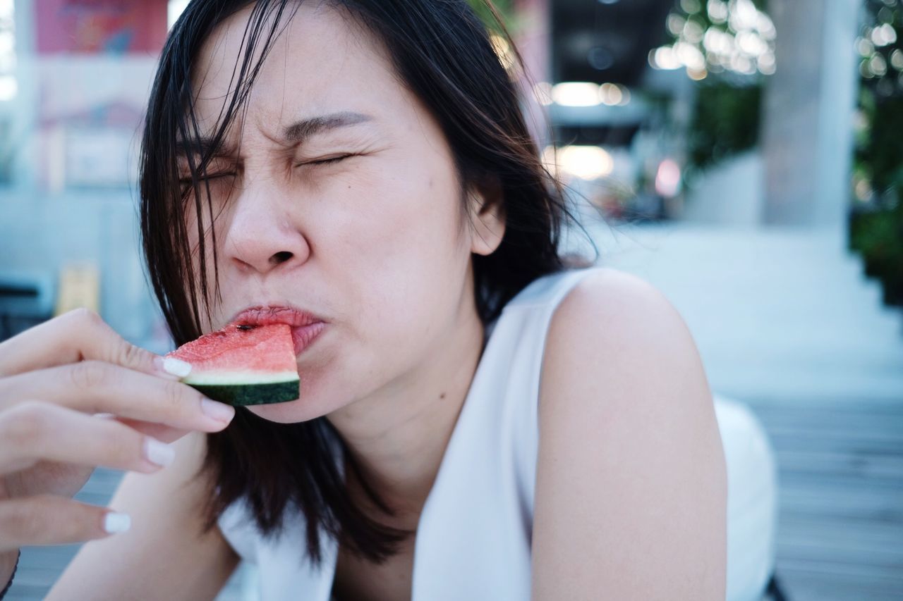 Close-up of woman eating watermelon slice