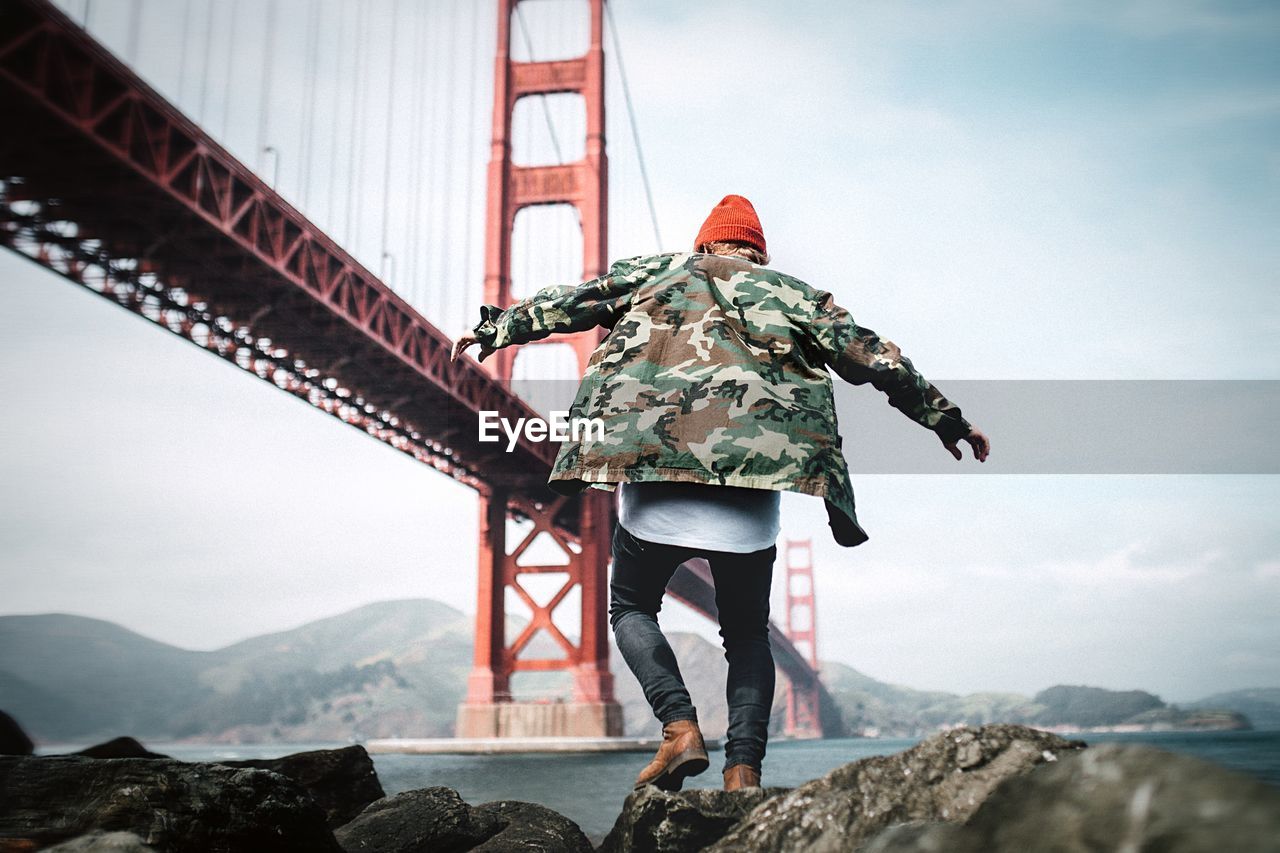 Rear view of man standing on rock