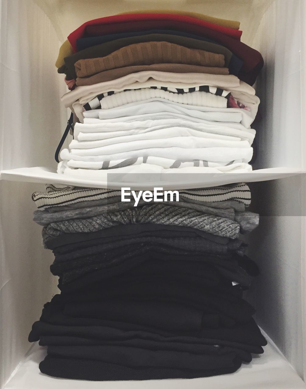 Stack of folded clothes in shelf