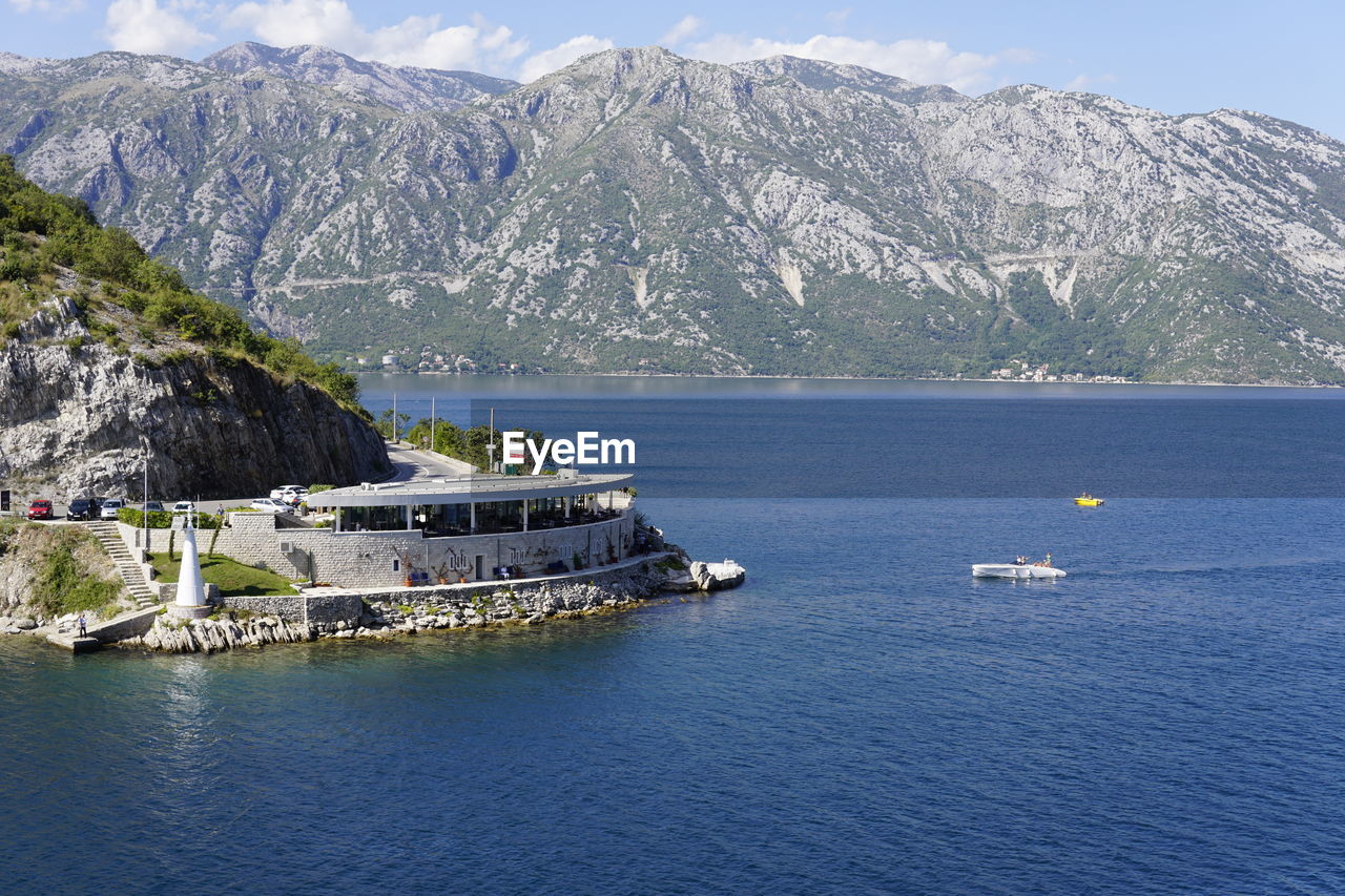 Scenic view of sea by mountains against sky