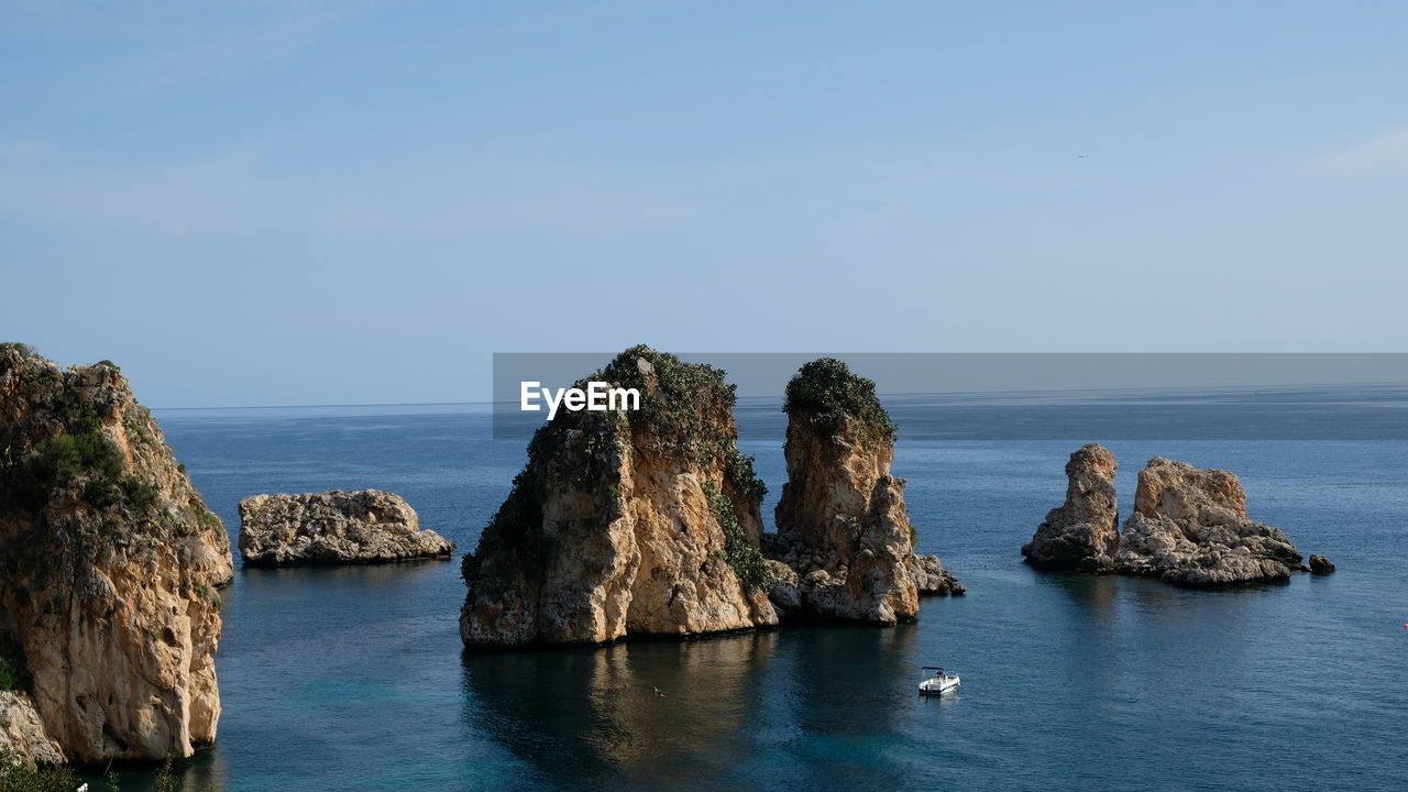 PANORAMIC VIEW OF ROCK FORMATIONS IN SEA AGAINST SKY