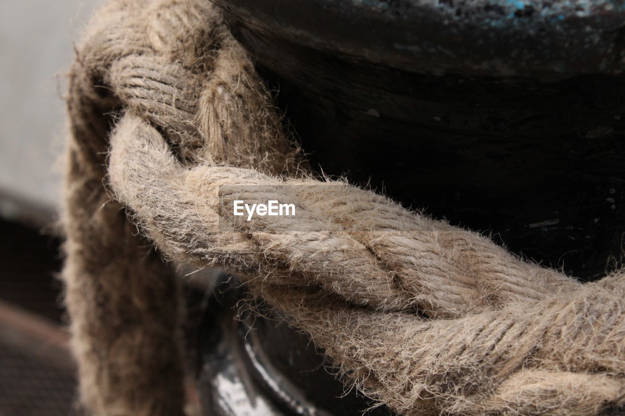 CLOSE-UP OF ROPE TIED UP ON WOODEN POST