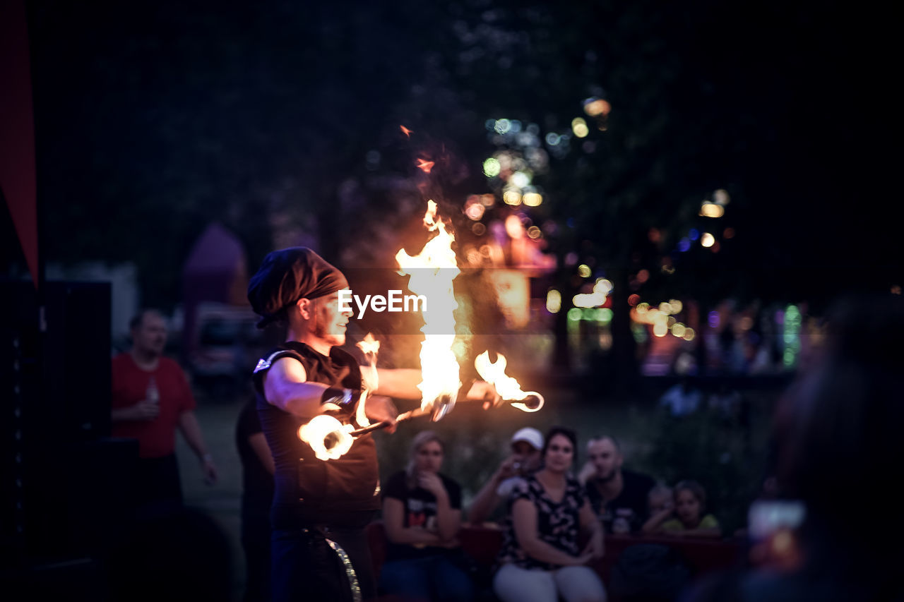 GROUP OF PEOPLE AT ILLUMINATED FIRE