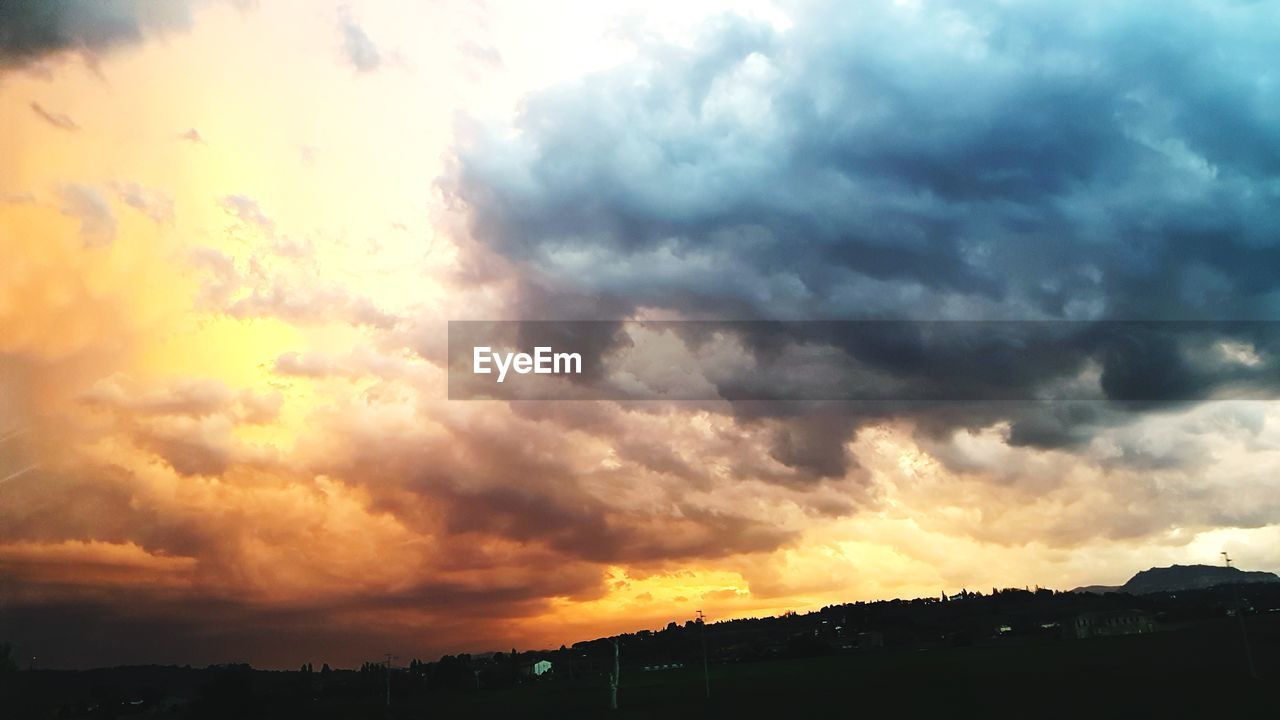 SCENIC VIEW OF SILHOUETTE LANDSCAPE AGAINST DRAMATIC SKY