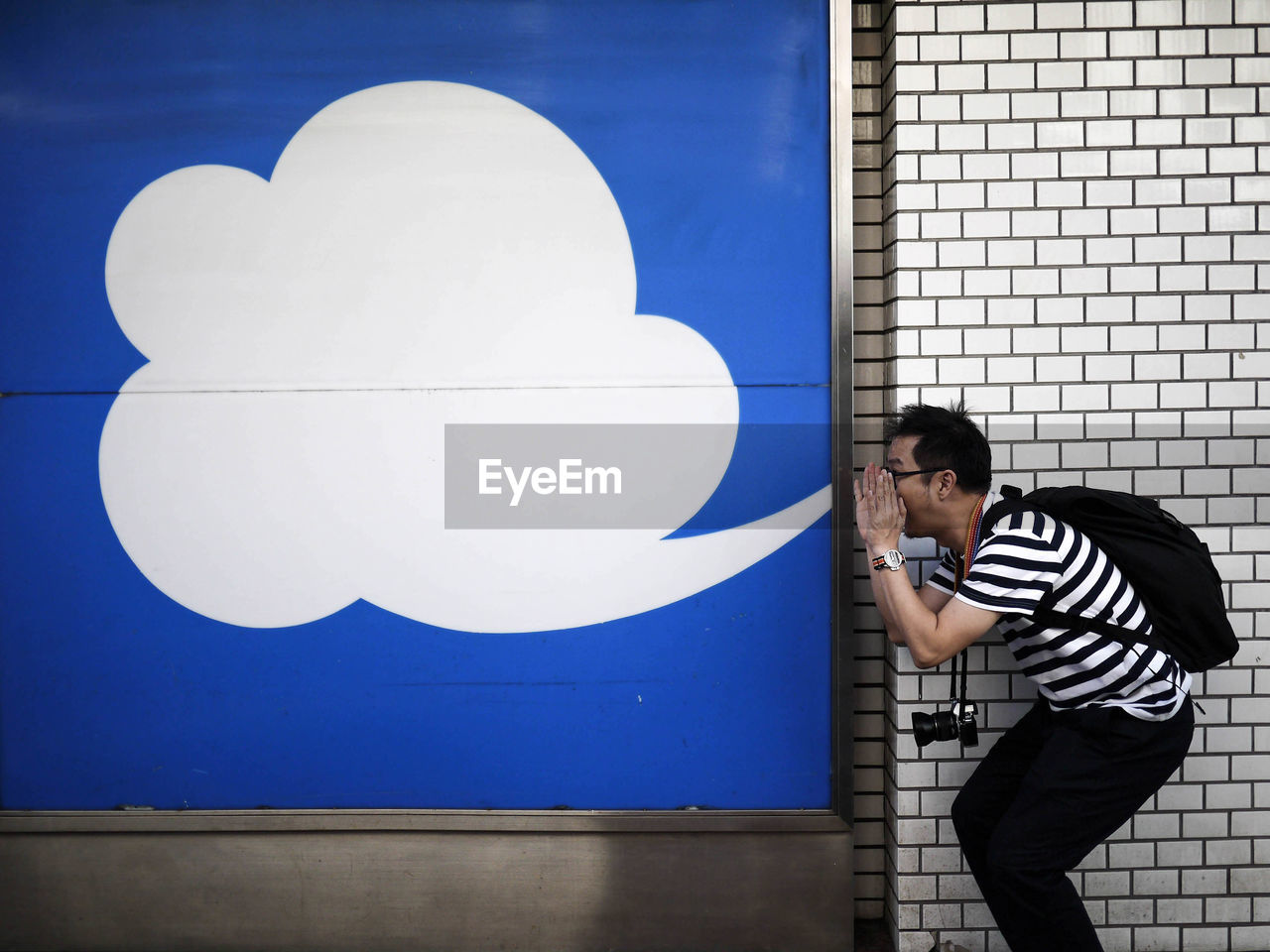 Optical illusion of man blowing cloud