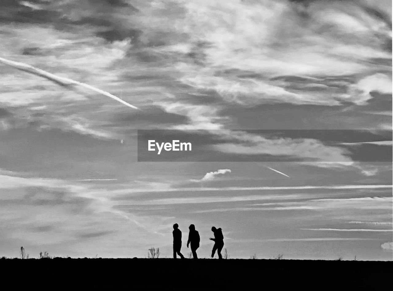 SILHOUETTE PEOPLE STANDING ON FIELD