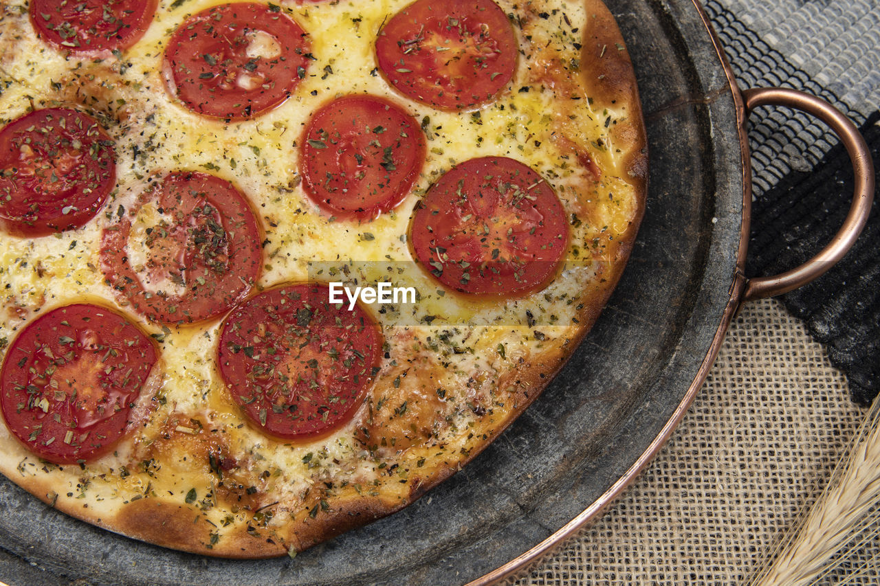 Neapolitan brazilian pizza with mozzarella cheese and tomato slices with oregano, top view