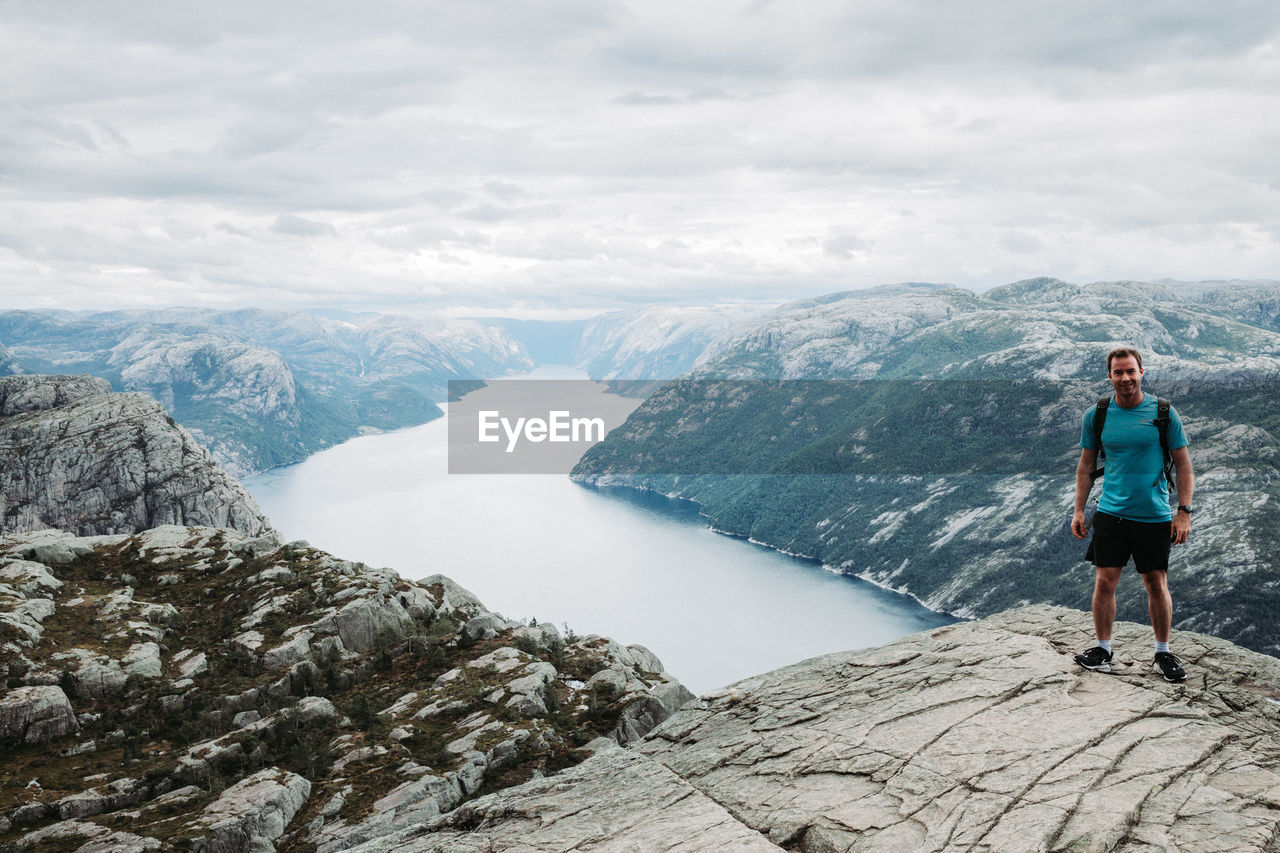 rear view of man walking on mountain against sky