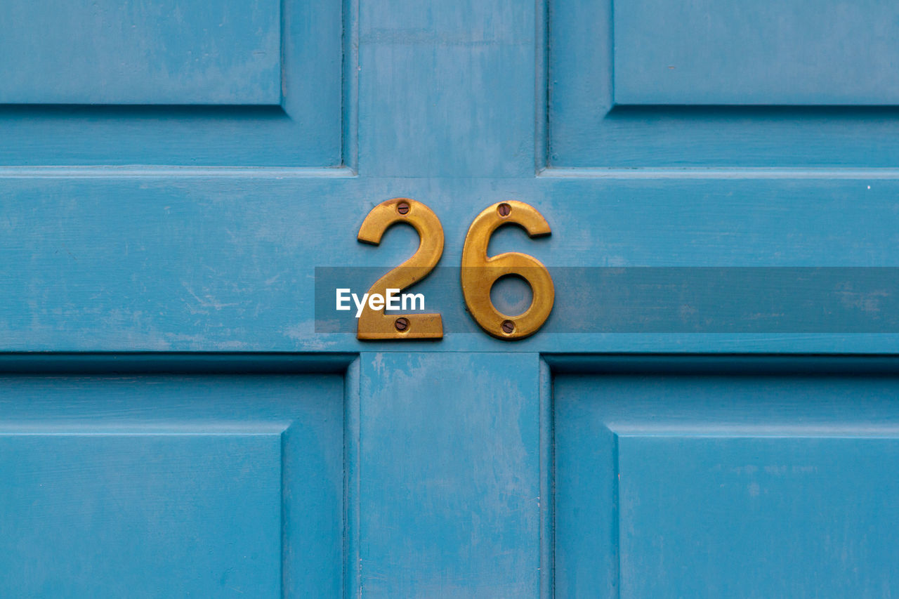 House number 26 on a blue wooden front door in london 