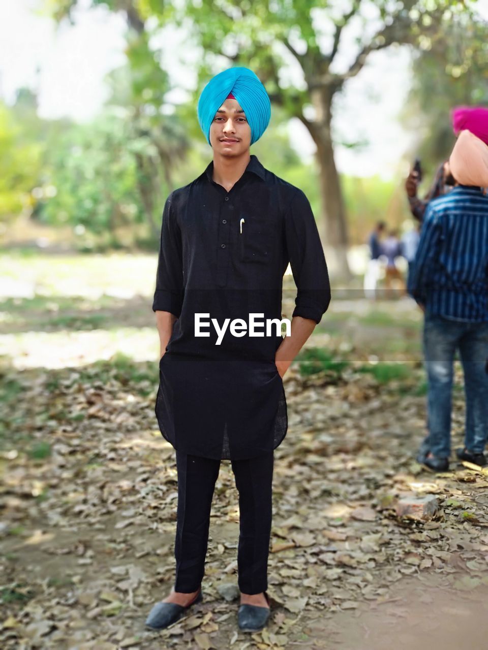 Portrait of smiling man wearing turban standing on land