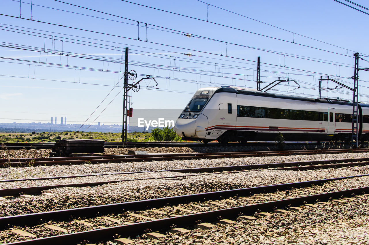 TRAIN ON RAILROAD TRACK AGAINST SKY