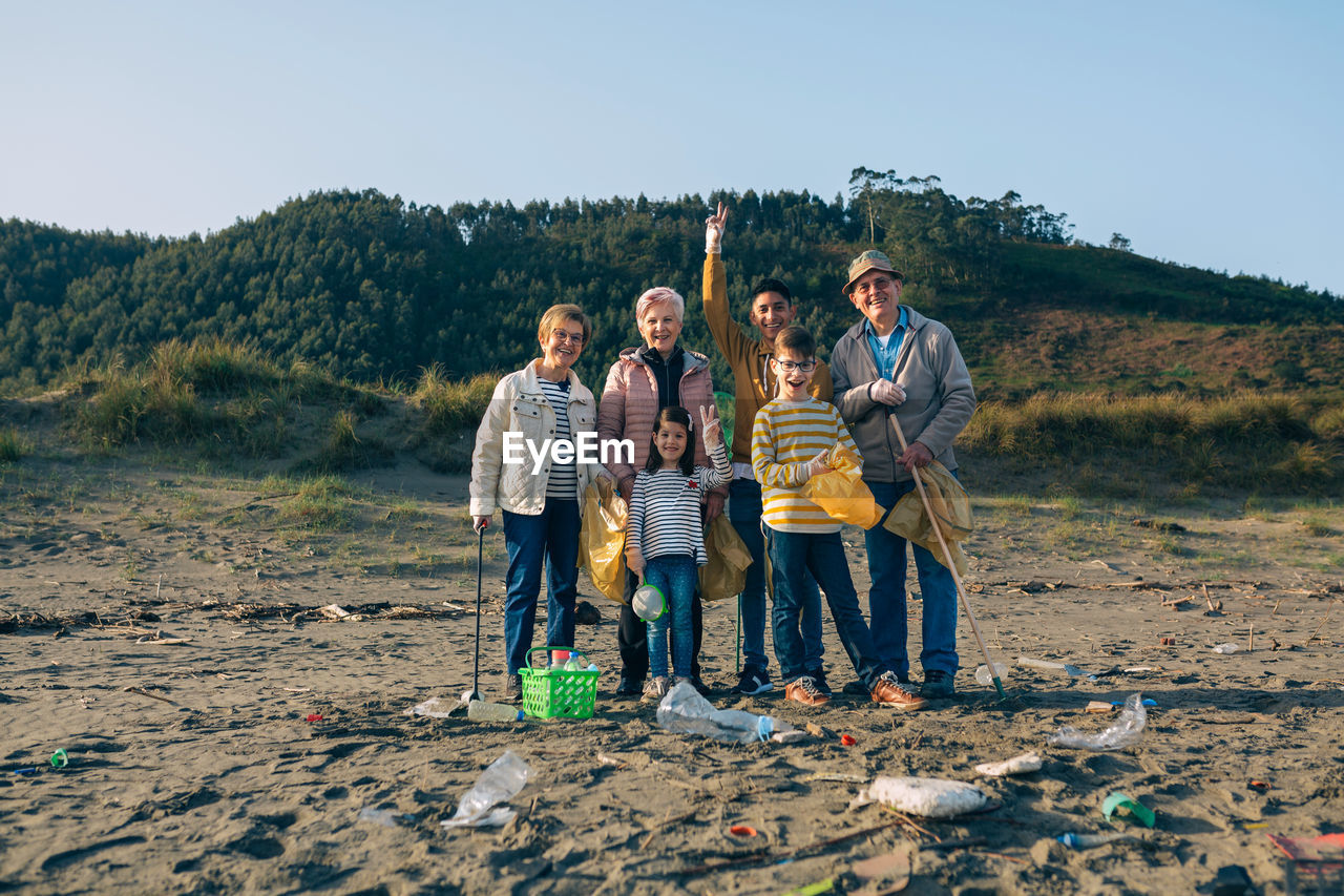 Portrait of happy family cleaning beach