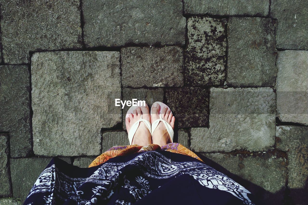 Low section of woman standing on footpath