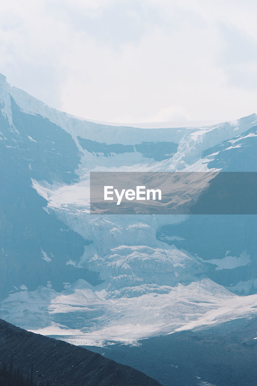 Aerial view of snowcapped mountains against sky