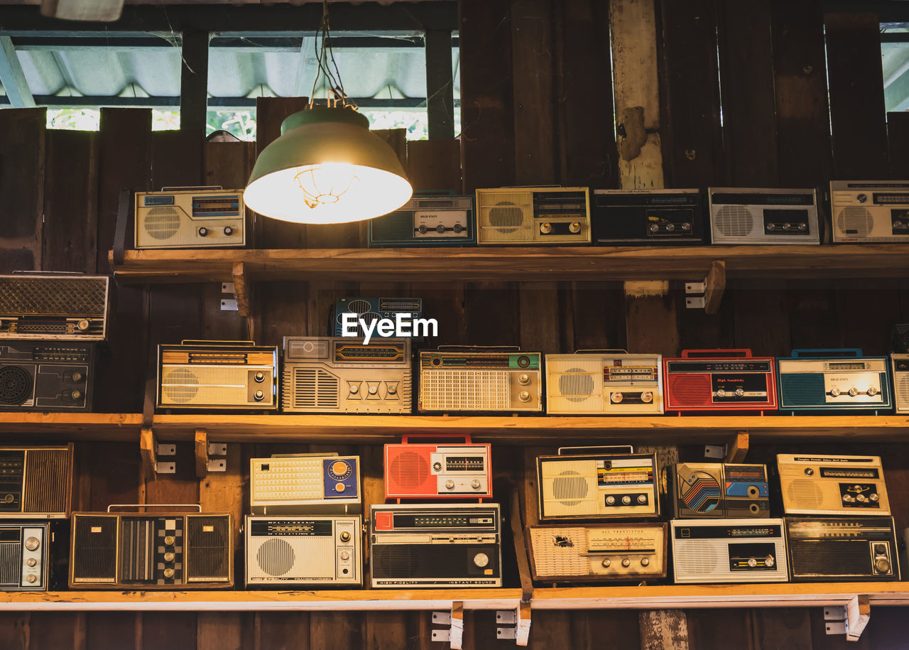 Old radios on shelf in illuminated room