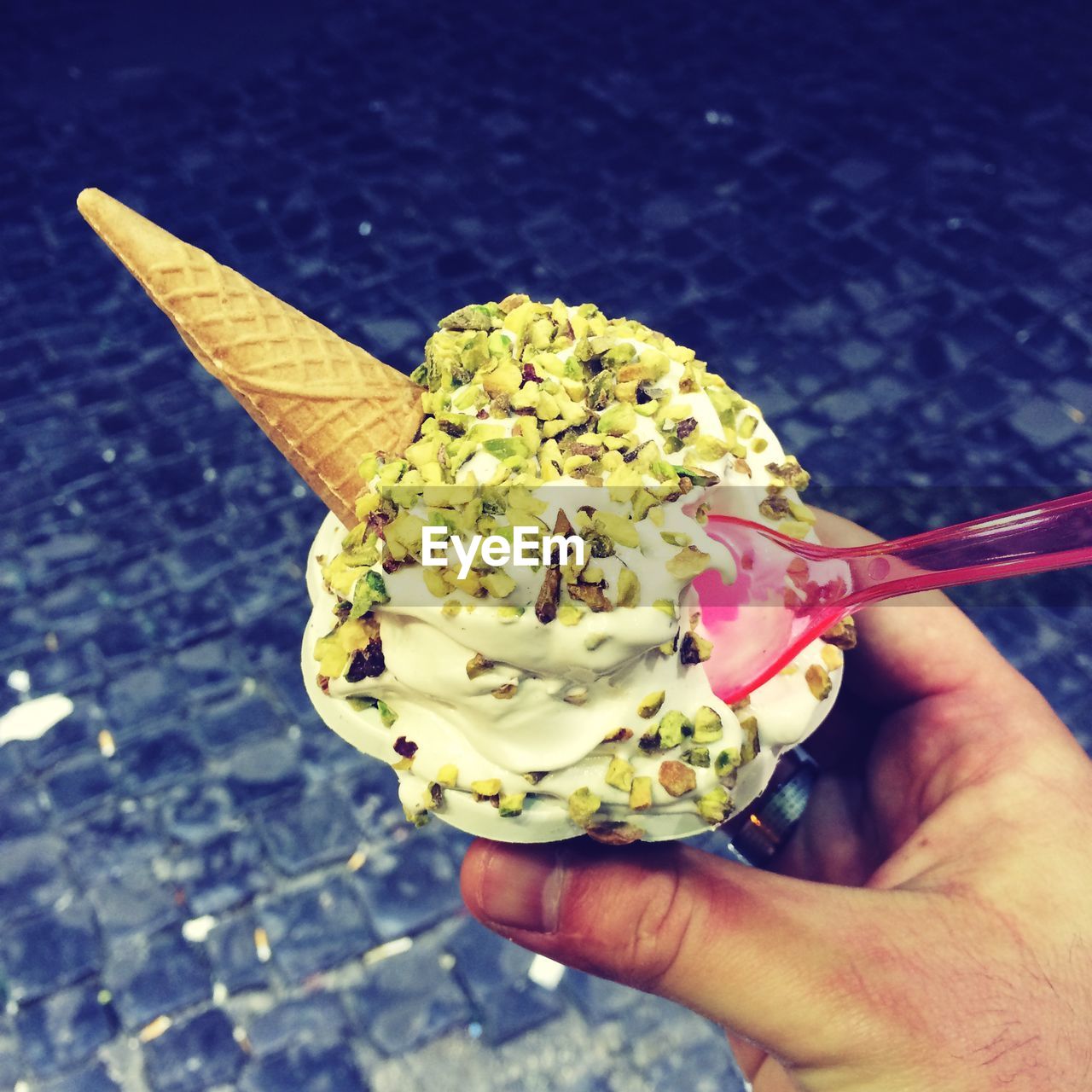 Close-up of person hand holding vanilla ice cream with cone