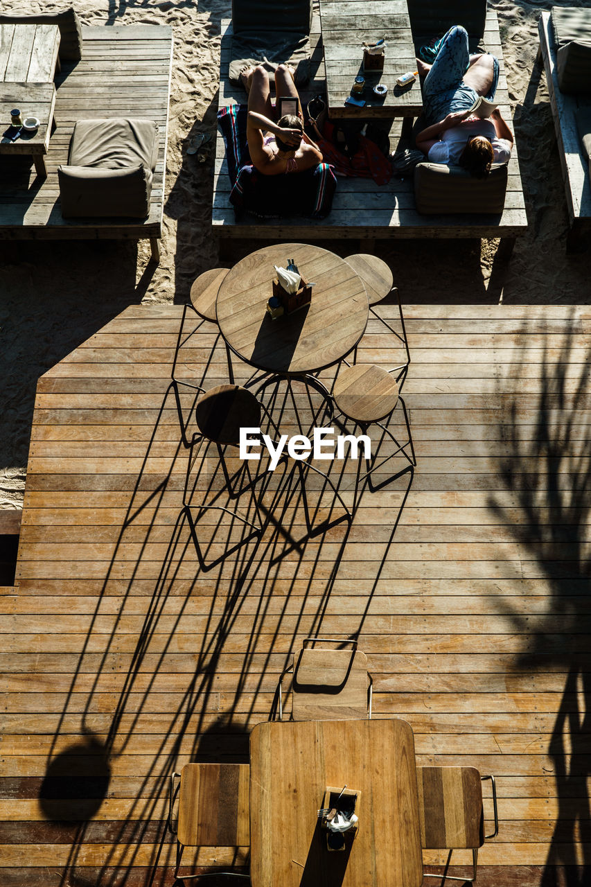 High angle view of men relaxing by patio at beach