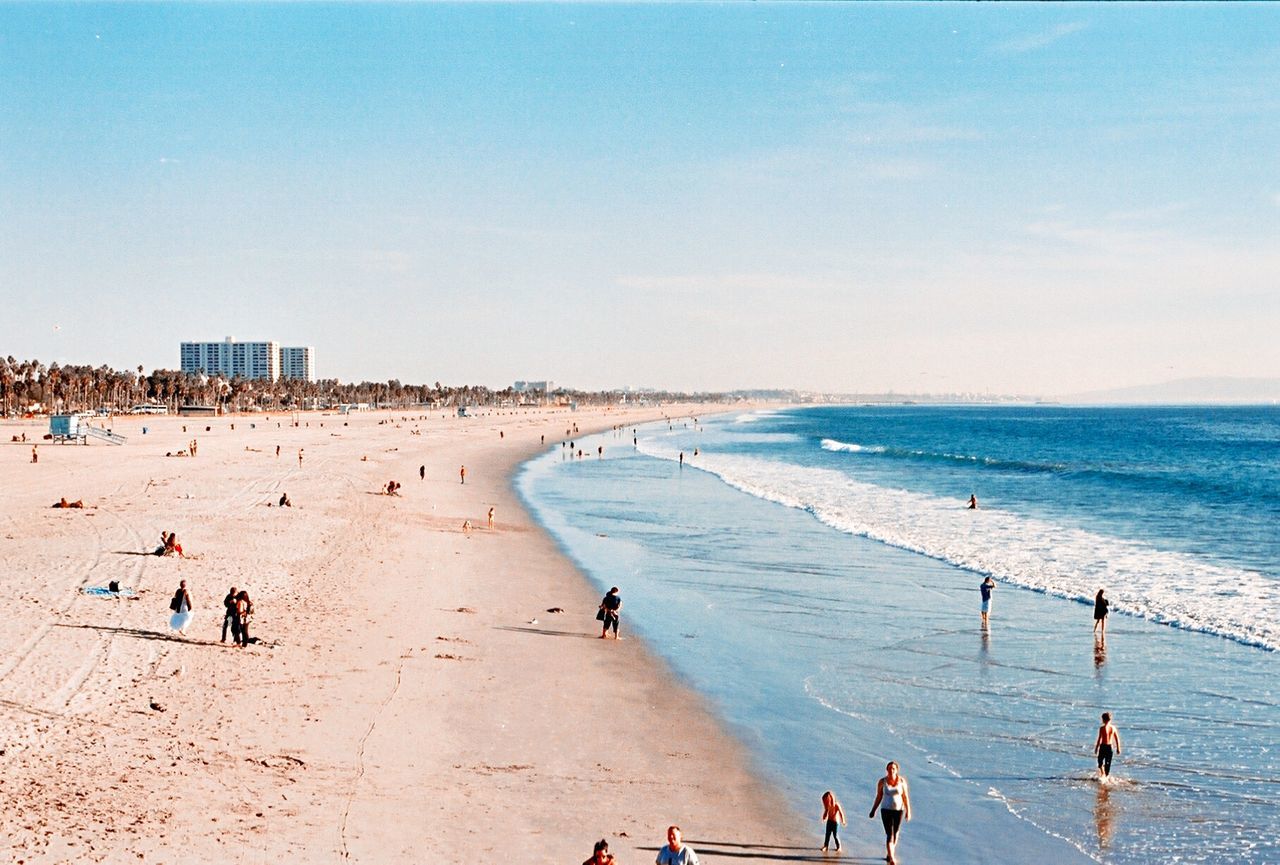 People at beach against sky