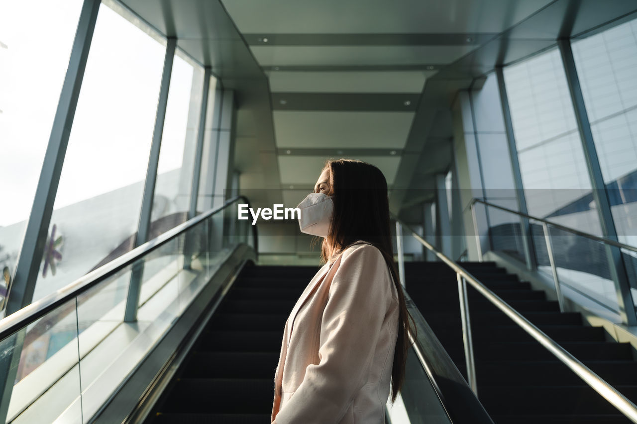 Side view of woman standing on railing