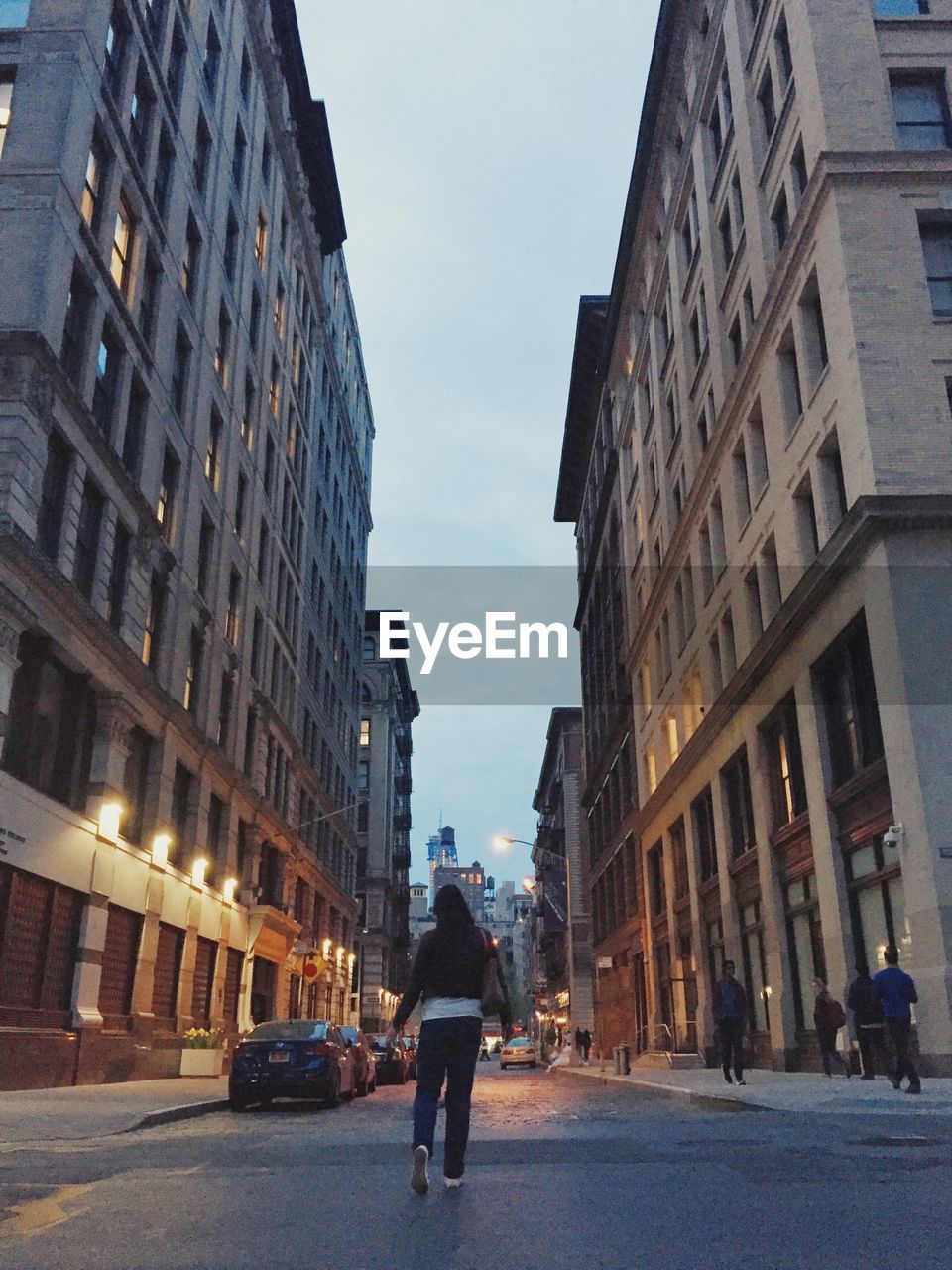 Rear view of man walking on street in city