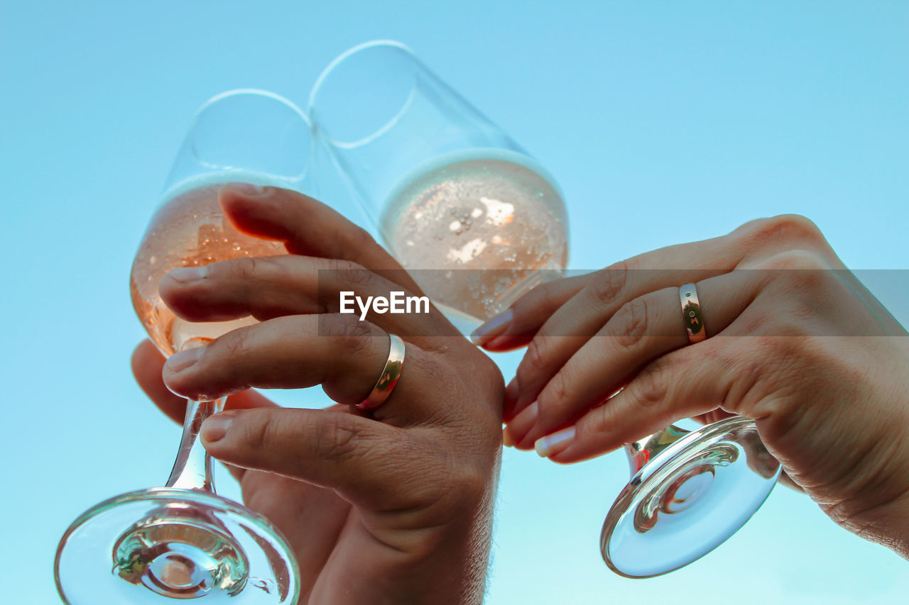 Low angle view of couple toasting champagne flutes 