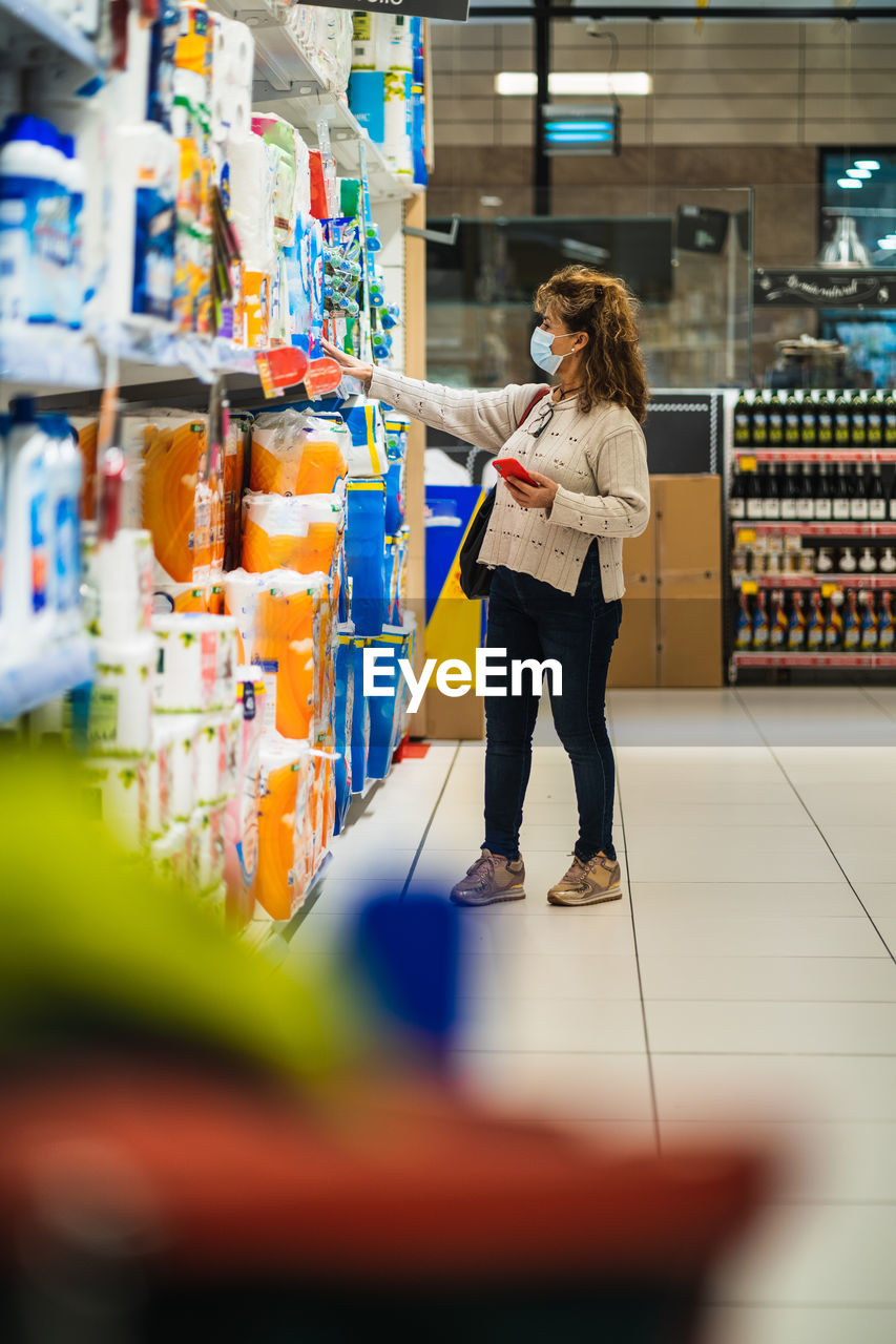 FULL LENGTH OF WOMAN STANDING AGAINST STORE