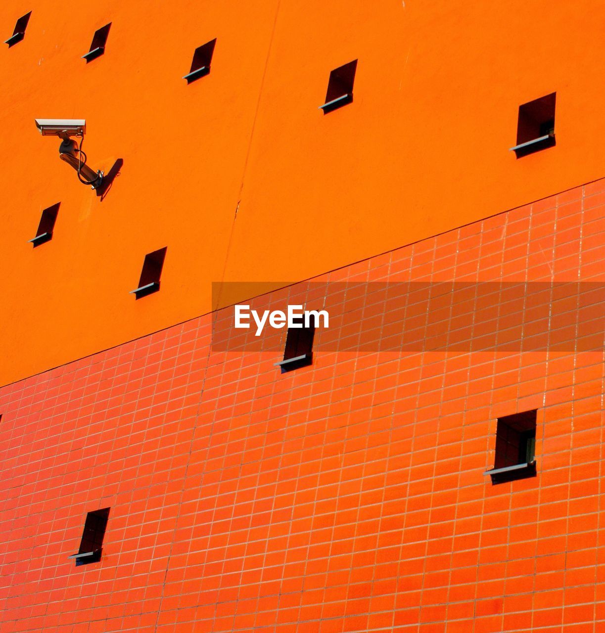 LOW ANGLE VIEW OF BUILDING WITH ORANGE WINDOWS