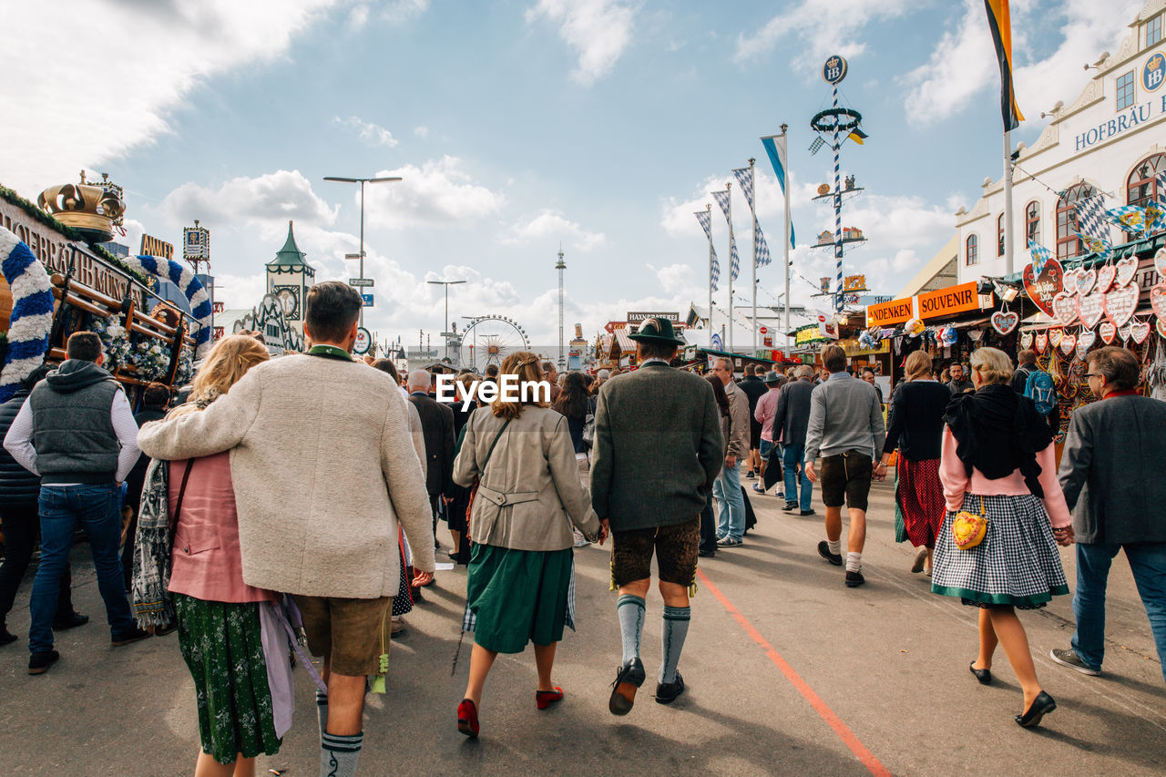 Rear view of people walking on street in amusement park