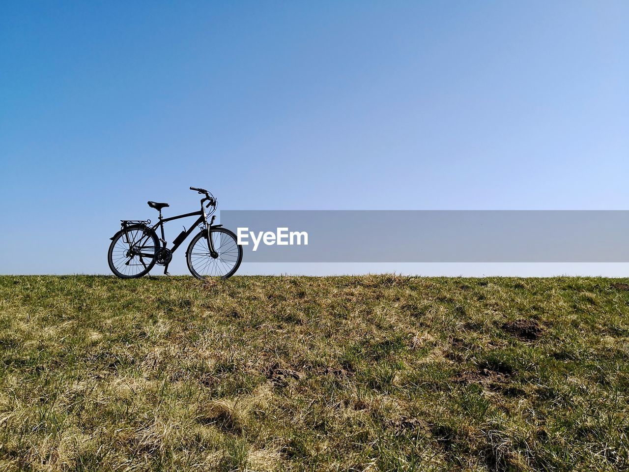 Bicycle on field against clear sky