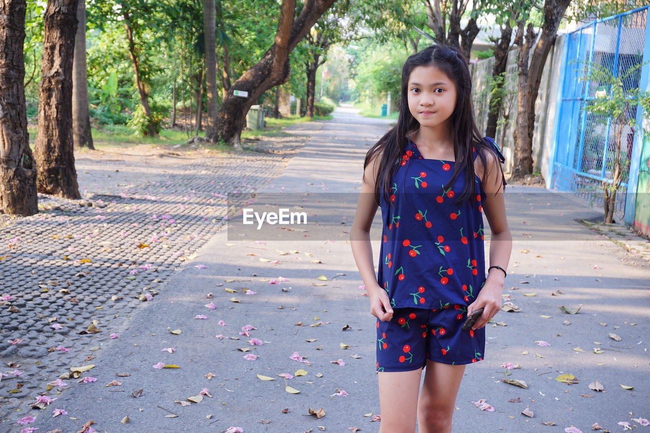 Portrait of young woman standing in park