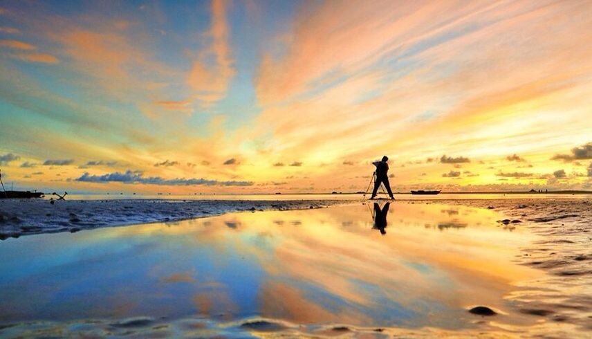 SILHOUETTE OF PEOPLE ON BEACH AT SUNSET