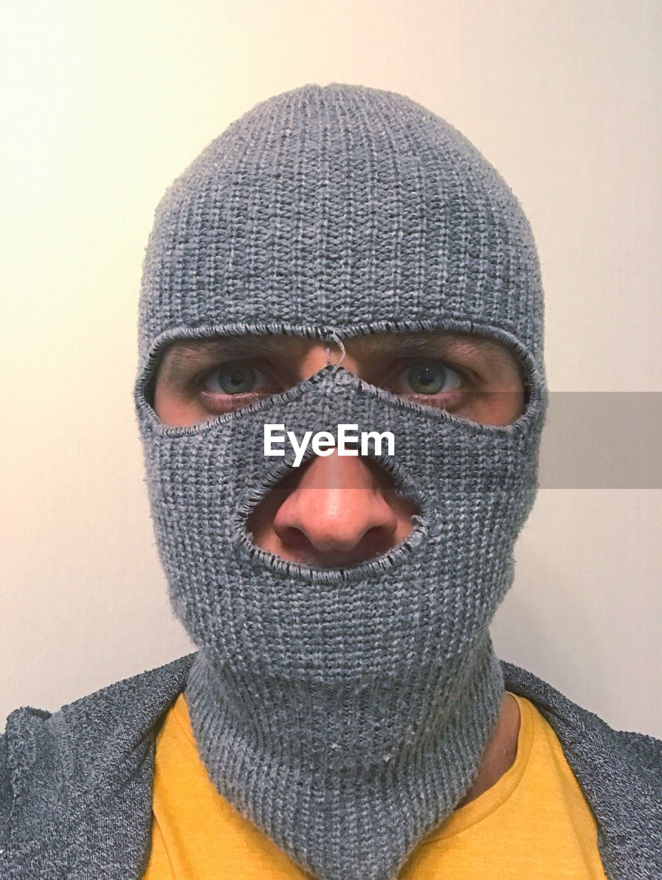 Close-up portrait of young man wearing balaclava by wall