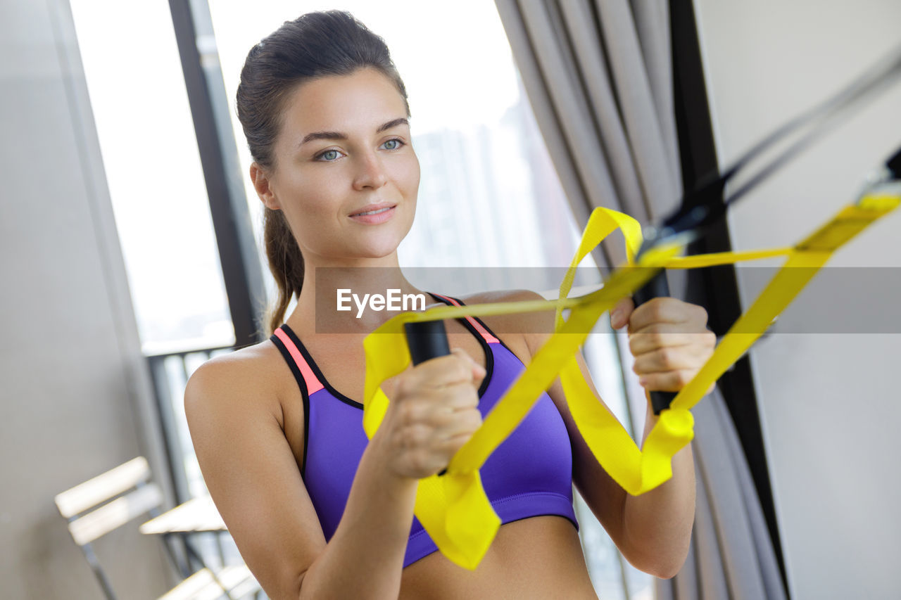 portrait of young woman exercising at gym