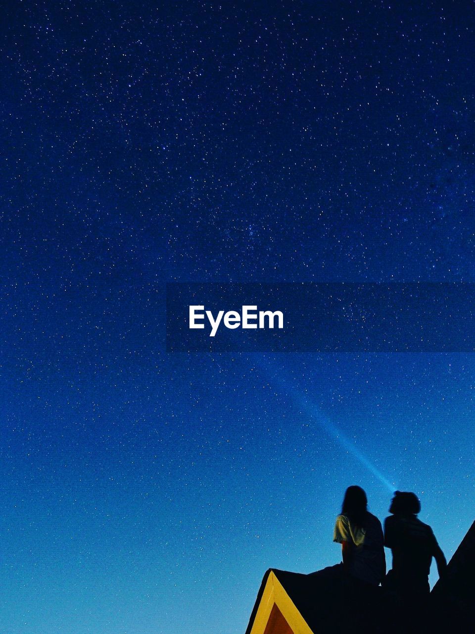 Low angle view of couple against star field