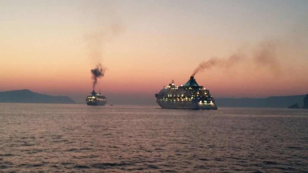 BOATS SAILING IN SEA AT SUNSET