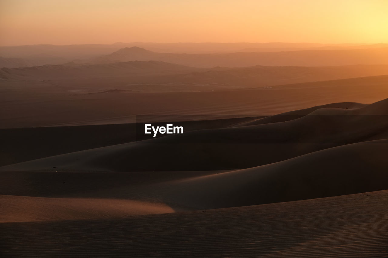 Scenic view of desert against sky during sunset