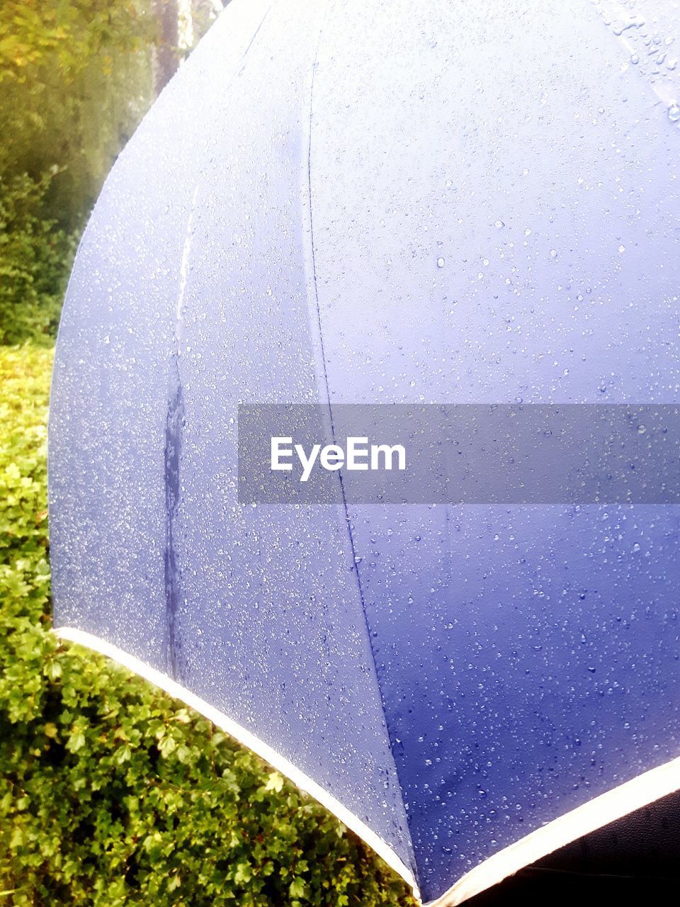 Close-up of wet umbrella against sky