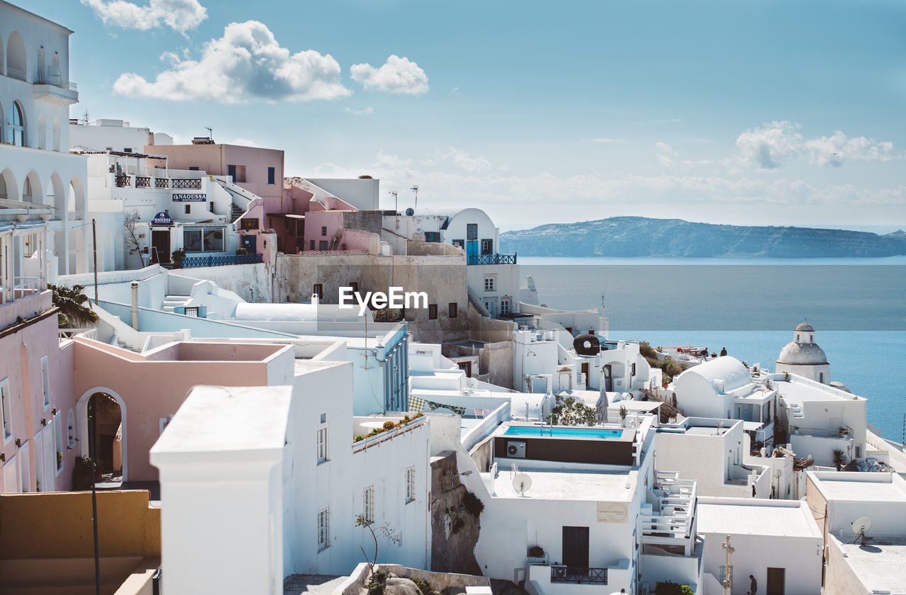 Residential buildings by sea against sky