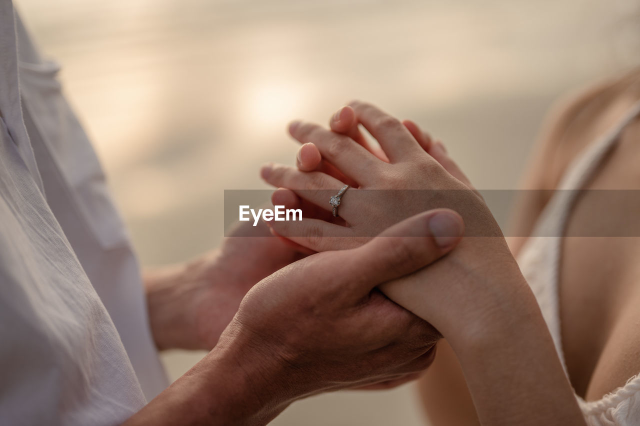 Midsection of couple holding hands