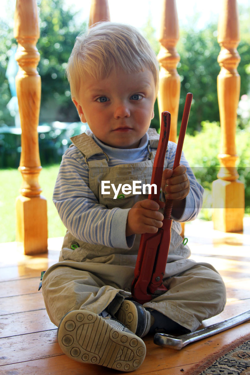 Portrait of cute boy sitting outdoors