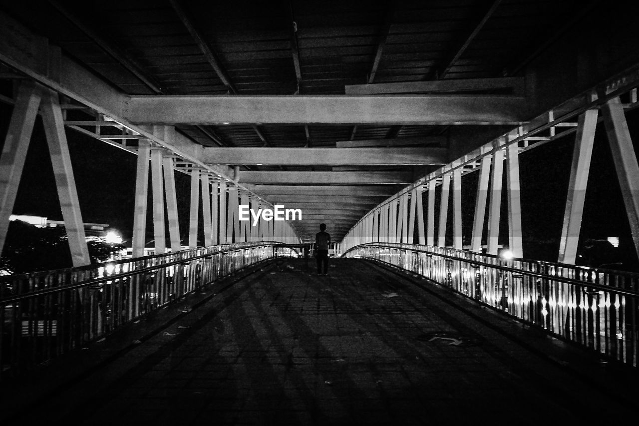 INTERIOR OF FOOTBRIDGE OVER ILLUMINATED BRIDGE