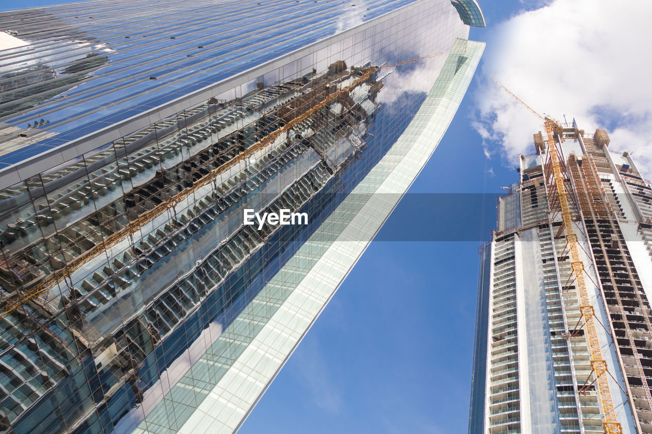 AERIAL VIEW OF BUILDINGS AGAINST CLOUDY SKY