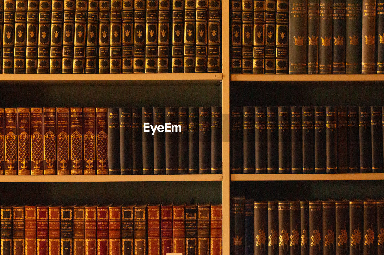 FULL FRAME SHOT OF BOOKS IN SHELF AT LIBRARY