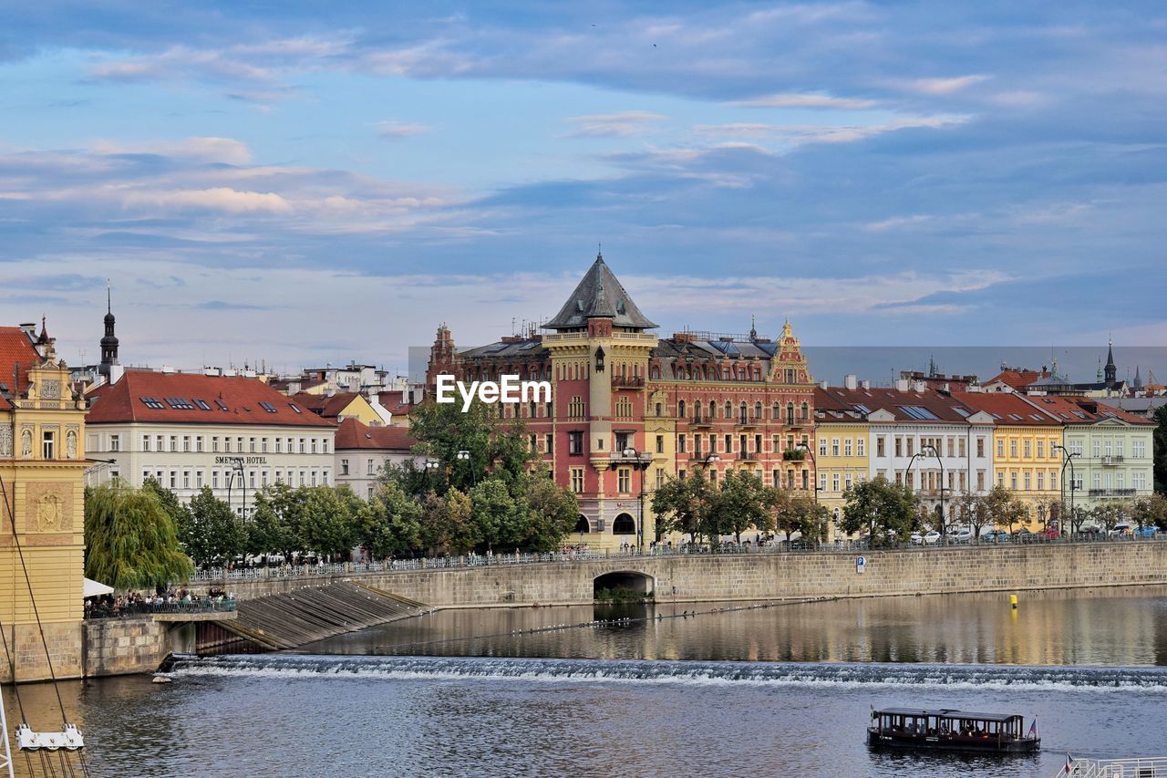 Buildings in city against cloudy sky