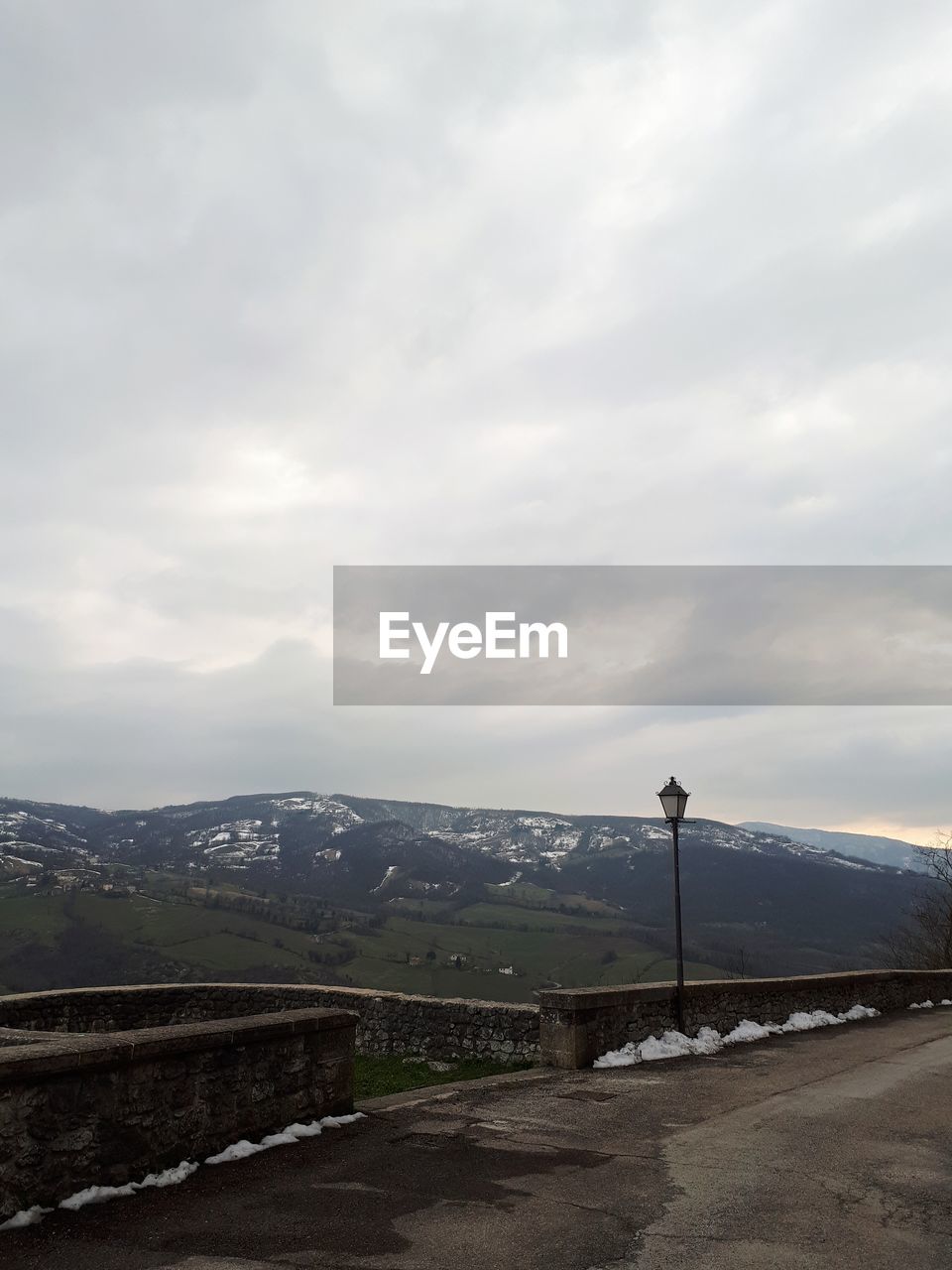 Road by mountains against sky