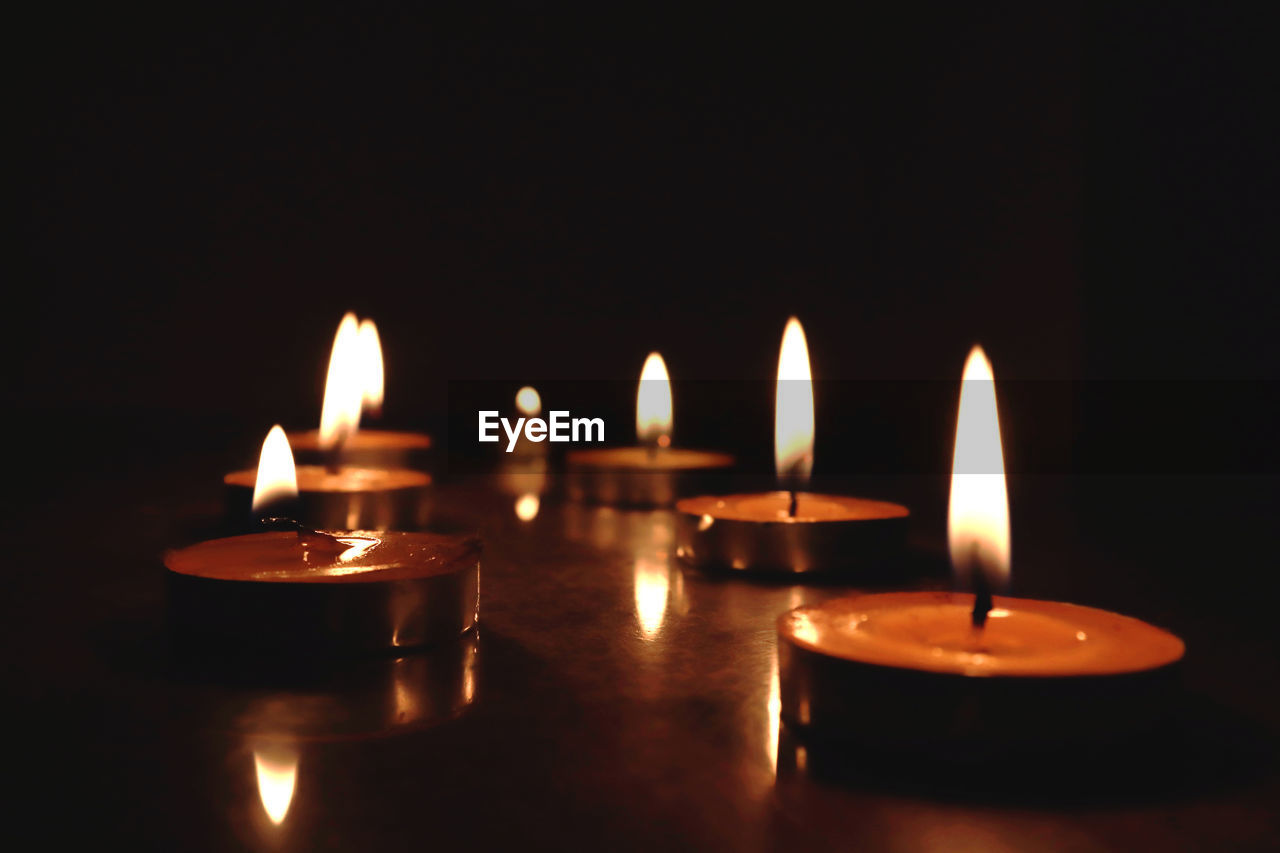 Close-up of lit candles on table