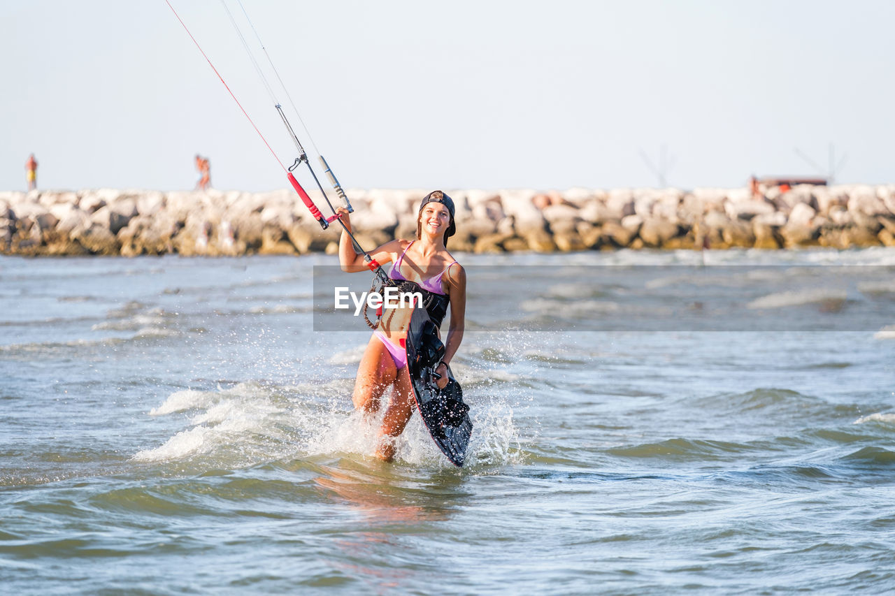 young man surfing in sea against clear sky