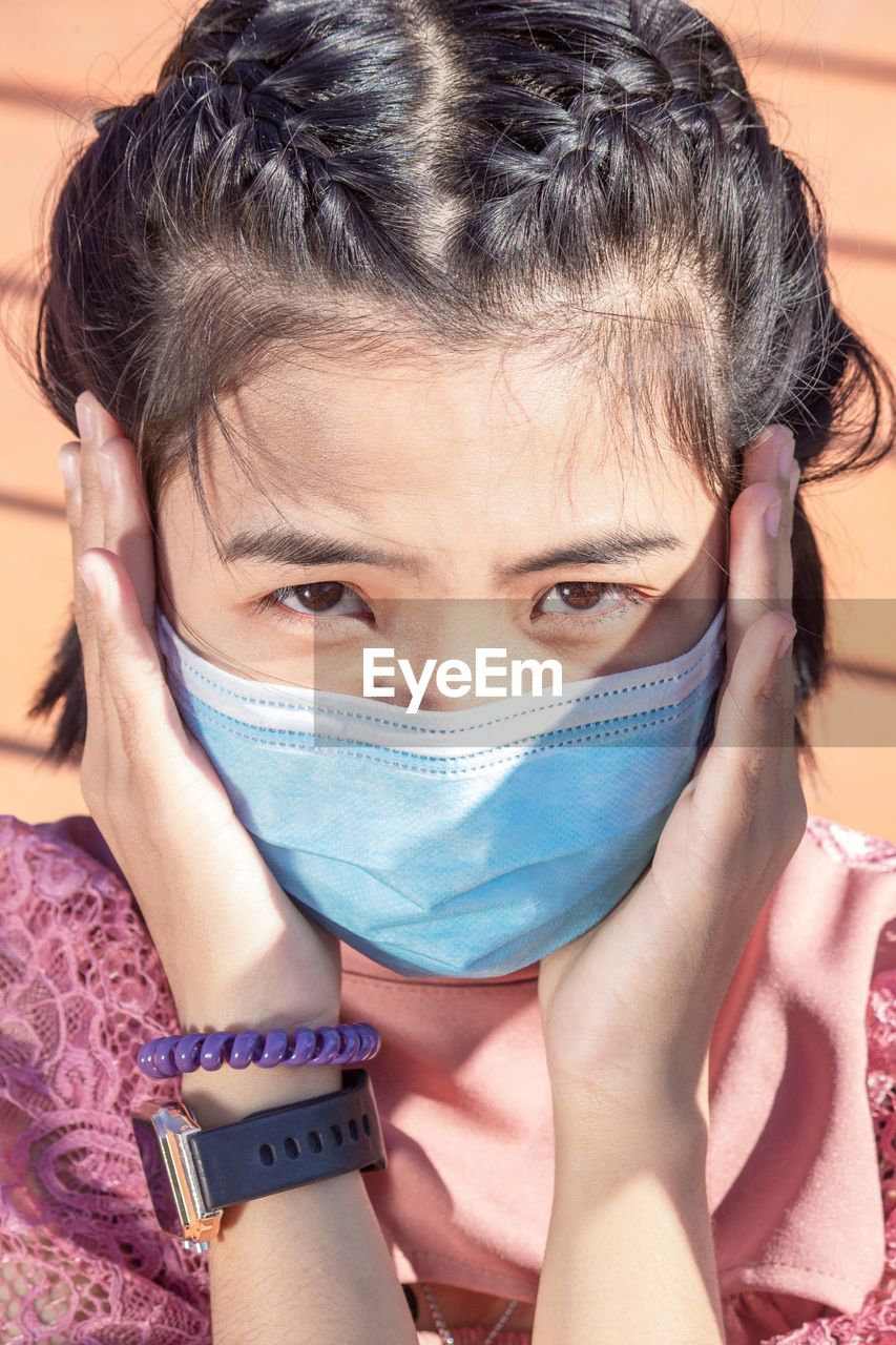 Close-up portrait of beautiful women wearing face masks looking straight at the camera. new normal