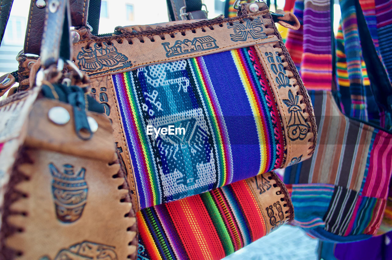 Close-up of sling bags hanging at market stall