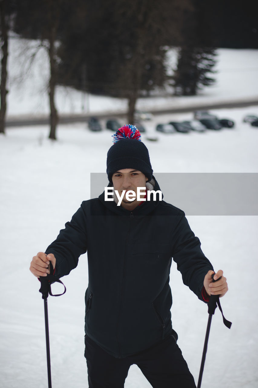 Closeup of a teenage man watching what is happening on the ski slope and in the beskydy valley 